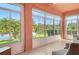 Bright and airy lanai with large windows offering a beautiful view of the lake and lush landscaping at 4322 Reflections Pkwy, Sarasota, FL 34233
