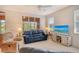 Comfortable living room with plush seating, a ceiling fan, large windows, and a TV on a modern stand at 4322 Reflections Pkwy, Sarasota, FL 34233