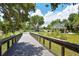 Scenic community park featuring a walking bridge, playground, and picnic areas at 4322 Reflections Pkwy, Sarasota, FL 34233