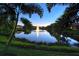Tranquil pond at twilight with a fountain feature and lush greenery at 4322 Reflections Pkwy, Sarasota, FL 34233