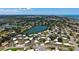 Wide aerial shot of a home located near a lake, surrounded by homes and greenery at 445 Matisse S Cir # 445, Nokomis, FL 34275