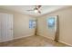 Bright bedroom with wood-look flooring, two windows with outdoor views, and a ceiling fan at 445 Matisse S Cir # 445, Nokomis, FL 34275