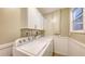 Convenient laundry room with washer, dryer, overhead cabinets, and a window at 445 Matisse S Cir # 445, Nokomis, FL 34275