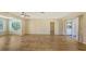 Bright, open living room with wood-look flooring, large windows, and sliding glass door to the outside at 445 Matisse S Cir # 445, Nokomis, FL 34275