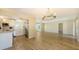 Open-concept living room and kitchen feature wood-look flooring, neutral paint, and bright, open spaces at 445 Matisse S Cir # 445, Nokomis, FL 34275