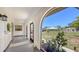 View of a screened-in front porch with a tiled floor and arched doorway to the main house at 445 Matisse S Cir # 445, Nokomis, FL 34275