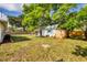 Expansive backyard with lush lawn, privacy fence, and cozy cottage-style shed featuring blue accents at 4528 58Th W St, Bradenton, FL 34210