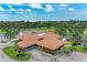 Aerial view of community clubhouse, tennis courts, and pool surrounded by tropical landscaping at 4644 Red Maple Rd # 1303, Bradenton, FL 34210