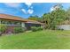 Well-maintained backyard with green grass, lush plants, and a screened porch at 4644 Red Maple Rd # 1303, Bradenton, FL 34210