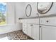 Bathroom with shaker cabinets, vanity with double mirrors, and decorative tile flooring at 4928 Hidden Oaks Trl, Sarasota, FL 34232