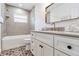 Stylish bathroom featuring tile flooring, gray tiled shower, and modern vanity with gold fixtures at 4928 Hidden Oaks Trl, Sarasota, FL 34232