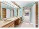 Bathroom with a double sink vanity and an open view to the primary bedroom at 5273 Myrtle Wood # 37, Sarasota, FL 34235