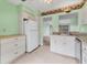 A view of the kitchen with bright green walls and white appliances at 5273 Myrtle Wood # 37, Sarasota, FL 34235