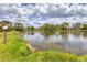 Scenic view of a tranquil pond surrounded by lush greenery, under a cloudy sky at 5273 Myrtle Wood # 37, Sarasota, FL 34235