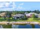 Home overlooking a serene pond, featuring a screened-in lanai and lush landscaping at 5320 Layton Dr, Venice, FL 34293