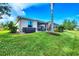 Lush backyard with green lawn, a hot tub, and a covered patio area at 5320 Layton Dr, Venice, FL 34293