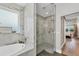 Elegant bathroom featuring a glass-enclosed shower and soaking tub with decorative tile surround at 5320 Layton Dr, Venice, FL 34293