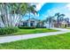 Charming single-story home with lush landscaping, palm trees, and a well-manicured lawn at 5320 Layton Dr, Venice, FL 34293