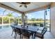 Screened patio with dining table and chairs overlooking the pool and serene lake view at 5320 Layton Dr, Venice, FL 34293