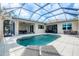 Beautiful pool area with a screened enclosure, tile patio, and multiple seating areas at 5320 Layton Dr, Venice, FL 34293