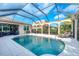 Private screened pool with outdoor lounge area, dining set, and well-manicured landscaping at 5320 Layton Dr, Venice, FL 34293