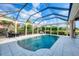 Inviting pool with screened enclosure, patio dining, and lush tropical landscaping at 5320 Layton Dr, Venice, FL 34293