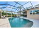Sparkling pool with screened enclosure, lush landscaping, and outdoor lounge seating at 5320 Layton Dr, Venice, FL 34293