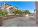 Large balcony with a low concrete fence, outdoor lighting and overlooking nearby trees and a building at 5531 Cannes Cir # 201, Sarasota, FL 34231