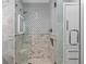 Luxurious bathroom shower featuring decorative tile work, glass enclosure, and built-in niche at 5531 Cannes Cir # 201, Sarasota, FL 34231