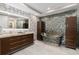 Elegant bathroom with stylish bathtub, wood cabinets, and patterned accent wall at 5531 Cannes Cir # 201, Sarasota, FL 34231