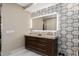 Bathroom featuring illuminated mirror, granite countertops, and tiled accent wall at 5531 Cannes Cir # 201, Sarasota, FL 34231