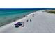 An aerial view of the beach with bright blue skies, clear water, and pristine white sand at 5531 Cannes Cir # 201, Sarasota, FL 34231