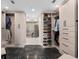 Large walk-in closet featuring custom shelving and drawers with grey tiled flooring at 5531 Cannes Cir # 201, Sarasota, FL 34231