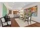 Bright dining room features modern glass table, hardwood floors, and an open layout to the kitchen at 5531 Cannes Cir # 201, Sarasota, FL 34231