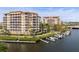 Mediterranean-style building with water views and private boat docks, surrounded by lush landscaping and palm trees at 5531 Cannes Cir # 201, Sarasota, FL 34231