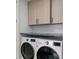 Functional laundry room with front load washer and dryer and built-in cabinets at 5531 Cannes Cir # 201, Sarasota, FL 34231