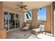 Spacious patio with outdoor seating and ceiling fan overlooking trees and a view of the ocean at 5531 Cannes Cir # 201, Sarasota, FL 34231