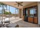 Covered patio with seating area, outdoor kitchen, mini fridge, and view of the lush landscaping at 5531 Cannes Cir # 201, Sarasota, FL 34231