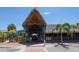 Spacious outdoor restaurant featuring a thatched roof, palm trees, and a lively atmosphere at 5531 Cannes Cir # 201, Sarasota, FL 34231