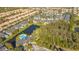 Community aerial view featuring a pool, lake, and multiple residential buildings at 5681 Bidwell Pkwy # 102, Sarasota, FL 34233