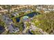 Aerial view of community with lake, pool, and multiple residential buildings at 5681 Bidwell Pkwy # 102, Sarasota, FL 34233