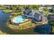 Community aerial showing lake and clubhouse with pool and palm trees at 5681 Bidwell Pkwy # 102, Sarasota, FL 34233