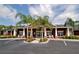 Exterior view of community clubhouse with palm trees and ample parking at 5681 Bidwell Pkwy # 102, Sarasota, FL 34233