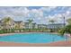 Resort-style community pool surrounded by palm trees and comfortable lounge chairs at 5681 Bidwell Pkwy # 102, Sarasota, FL 34233