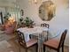 A sunlit dining area features a glass table, chandelier and an octagonal mirror at 5895 17Th W St # B-26, Bradenton, FL 34207