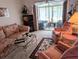 A living room with floral sofa and chairs with access to a screened porch at 5895 17Th W St # B-26, Bradenton, FL 34207