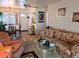 A cozy living room with floral sofa and chairs with dining room and front door views at 5895 17Th W St # B-26, Bradenton, FL 34207