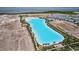 Aerial view of a sprawling community featuring a large Personal-made lagoon, palm trees, and modern home exteriors at 5910 Red Mangrove Ln, Bradenton, FL 34210
