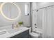 Bathroom with a vanity, round mirror, a tub and shower, and window offering natural light at 5910 Red Mangrove Ln, Bradenton, FL 34210