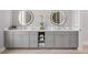 Bright bathroom features a double vanity, modern sinks, round mirrors and sleek, gray cabinetry at 5910 Red Mangrove Ln, Bradenton, FL 34210